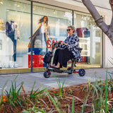 A lady riding her ATTO sport mobility scooter at a shopping mall